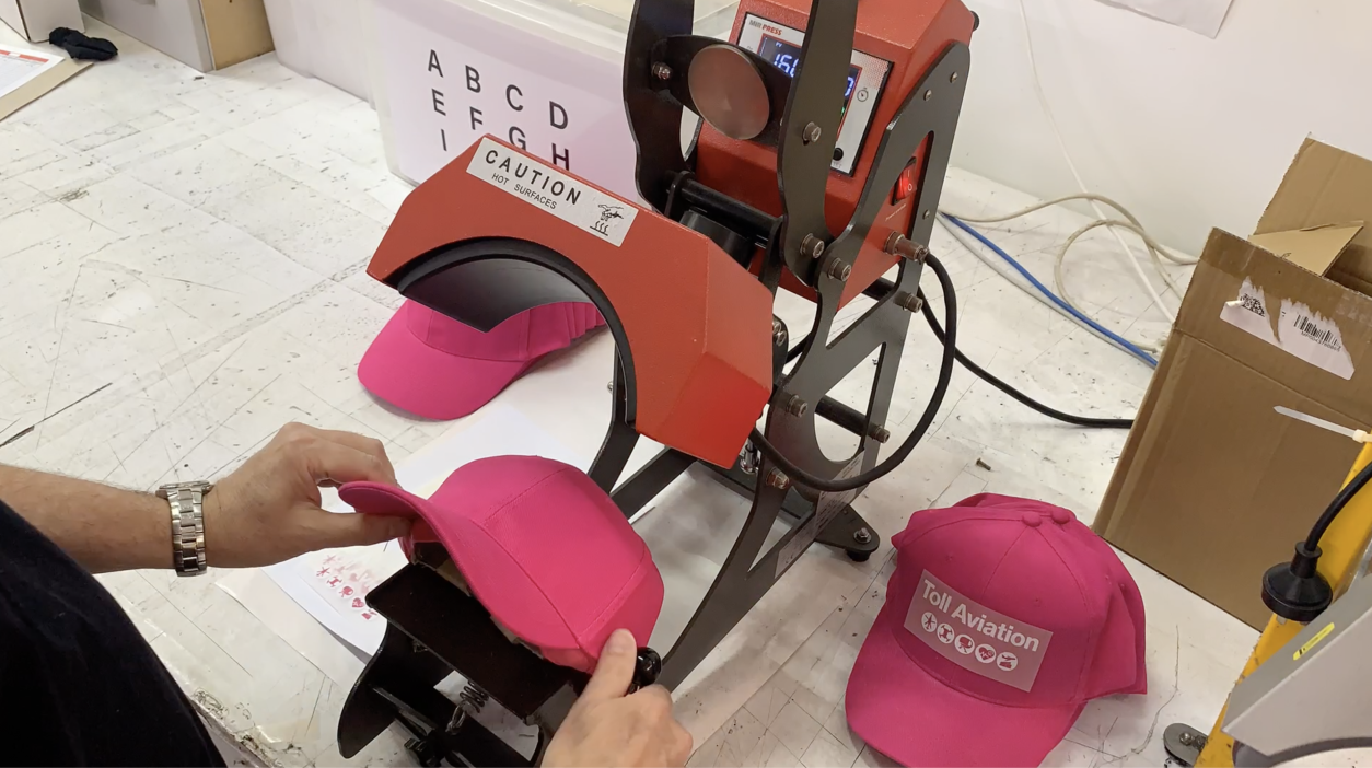 Look Design custom branded pink cap being heat-pressed with branding design